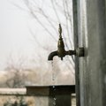 An outdoor faucet dripping water on a cold, gray day